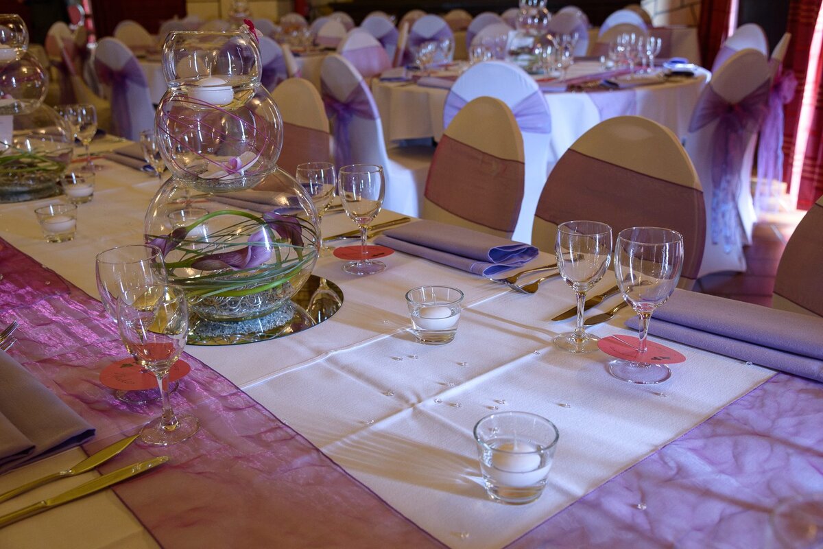 Table de mariage décorée avec composition florale en fishbowl et arts de la table au domaine Le Scaubecq