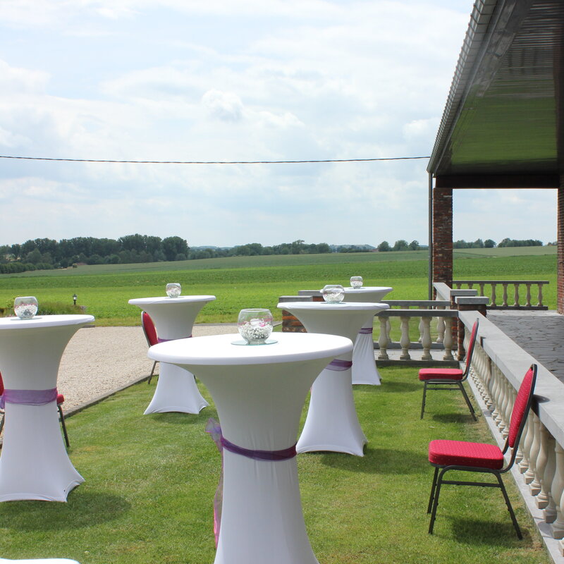 Terrasse extérieure du Scaubecq aménagée pour un vin d'honneur avec vue sur la campagne